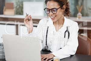 Doing an online consult. an attractive young female doctor working at her desk in the office.