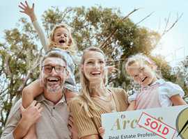 Portrait of happy caucasian family holding a sold sign while relocating and moving into a new house. Smiling parents and kids secure homeowner loan for property real estate and home purchase