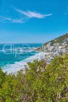Scenic seascape of Clifton beach, Cape Town, South Africa with hotels and holiday houses situated on a beachfront. Beautiful rock outcrops of mountaintops and nature near the coastline or bay