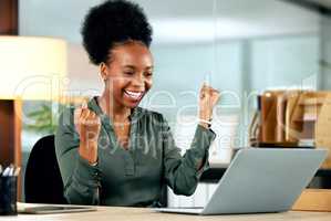 You can achieve anything you want. a young businesswoman cheering while using a laptop in an office at work.