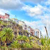 Colorful old vintage buildings in Santa Cruz de La Palma. Bright and vibrant classical architecture in a small city or village. Beautiful houses or homes with a rustic design with a palm tree growing