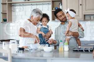 Grandma is baking and were here for it. Shot of a woman baking in the kitchen with her son and two grandchildren.