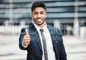 I approve this message. Cropped portrait of a handsome young businessman giving thumbs up while standing outside in the city.