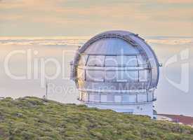 Closeup of an astronomical observatory with clear sky and copy space. Telescope surrounded by greenery and located on an island at the edge of a cliff. Roque de los Muchachos Observatory in La Palma