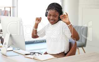 Take time for yourself too. a young businesswoman listening to music at work.
