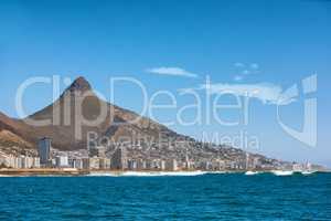 Coastal view of Cape Town and mountain landscape on a sunny day. View of the ocean and city against a blue horizon. A popular travel destination for tourists and hikers, in Lions Head, South Africa