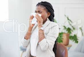 Allergy season is upon us. a businesswoman blowing her nose due to a cold at work.