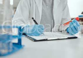 Test tubes are simply vials of happiness. a scientist holding a sample while making notes.