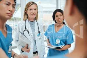 Even heroes make mistakes. a group of medical practitioners having a discussion in a hospital.