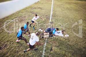 Above caucasian rugby player diving to score a try during a rugby match outside on a field. Male athlete making a dive to try and win the game for his team. Young man reaching out for the try line