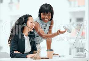 Showing her the ropes. an attractive young female call center agent and her supervisor working in the office.