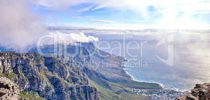 Beautiful scenic landscape of Table Mountain in Cape Town, Western Cape. Aerial view of the mountain and sky covered in clouds by the ocean. Tourist attraction showing its splendor on a summer day