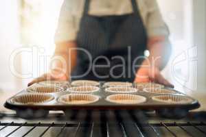 I hope these come out perfect. a woman taking a baking tray out of the oven.