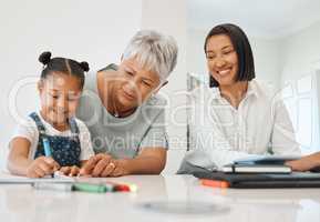 Thats a beautiful flower. a young girl getting help from her mother and grandma while doing her homework at home.