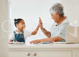 You got that right. a grandma helping her granddaughter at the kitchen table at home.