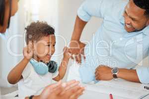 Our little genius. parents celebrating with their son while doing homework at home.