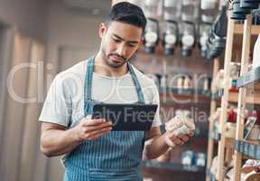 one young hispanic waiter using a digital tablet device while working in a store or cafe. Mixed race man checking inventory and stock of products while planning and browsing online