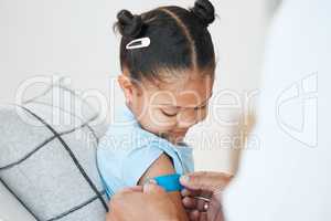 Is this your favourite colour. an unrecognizable doctor applying a plaster to a little girls arm after an injection at home.