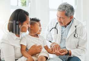 Can you hear what your pulse is saying. a mature doctor checking a little boys pulse during a checkup at home.