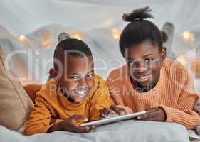 Cartoons before bedtime is a must. Portrait of a brother and sister using a digital tablet together at home.