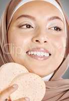 Young Arabic girl in hijaab with a smile. A beautiful middle-eastern Muslim lady wearing the abaya. .Close up of an Arabian woman with makeup puff in a strict cultural outfit and elegant appearance.