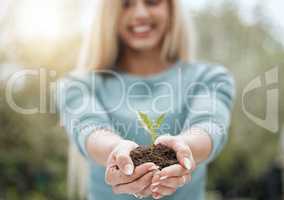 To new beginnings. a unrecognisable person holding a plant growing out of soil.