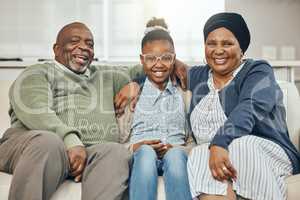 Passing on wisdom. two grandparents bonding with their grandchild on a sofa at home.