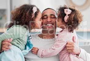 They are the beat of my heart. two little girls giving their father a kiss on the cheek at home.