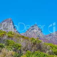 Famous mountain hiking destination with copy space, green forest trees and woods in Cape Town, South Africa. Landscape view of the Twelve Apostles Mountains with blue sky in a serene nature reserve