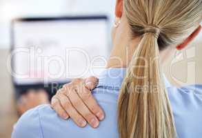 Young business woman rubbing neck in pain while working in office from behind. Young business woman rubbing neck in pain while working in office from behind.