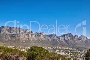 Beautiful mountain panorama with a clear blue sky and urban city with copy space in South Africa. Wide angle view of The twelve apostles with houses and trees, popular landmark and travel location