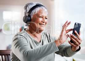 Play that song again. a beautiful senior woman listening to music while sitting on the sofa at home.