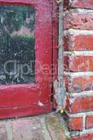 Closeup of abandoned red window covered in spiderwebs from neglect, poverty and economic crisis. Empty, old and dirty residential brick building or home in village with broken frame on the windowsill