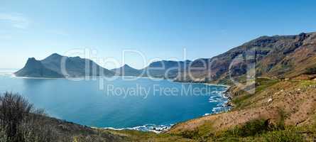 Wide angle panorama of mountain coastline against clear blue sky in South Africa. Scenic landscape of Twelve Apostles mountain range near a calm ocean in Hout Bay. Popular hiking location from above
