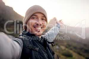 Selfies at the summit. Cropped portrait of a handsome young man taking selfies while hiking in the mountains.
