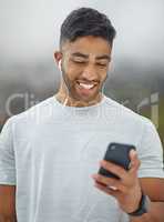 Music is an excellent companion to boost performance in training. a sporty young man wearing earphones and using a cellphone while exercising outdoors.
