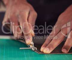 This work requires precision. an unrecognizable male designer working with leather in his design studio.