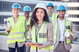 On site, on demand. Cropped shot of an attractive female construction worker standing outside on a building site with her colleagues.