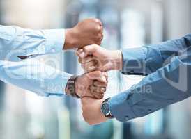 No letting go, no holding back. two unrecognizable businesspeople stacking their fists outside.