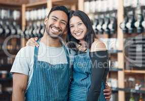 Portrait of a happy young hispanic man and woman working in a store or cafe. Friendly couple and coffeeshop owners managing a successful restaurant startup