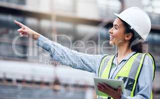 She always does her job thoroughly. a young female architect using a digital tablet at a building site.