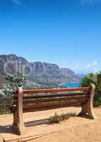 Bench with a relaxing view from Table Mountain, Cape Town, South Africa, soothing scene of Lions head against blue sky. Relaxing resting place along a hiking trail, with peaceful harmony in nature