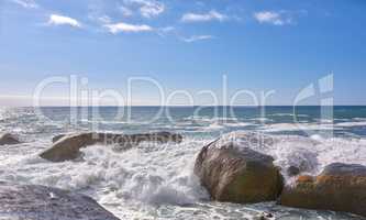 Copy space ocean view of beach with rocks, boulders and sea water washing onto rocky shore on peaceful summer vacation. Rough texture and detail of scenic coastline in tropical island resort overseas