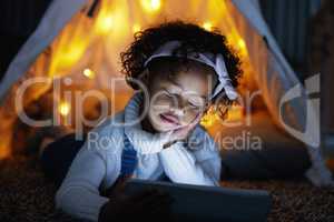 So tired but I cant switch off. an adorable little girl using a digital tablet during bedtime at home.