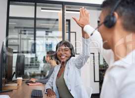 Luck is great, but most of life is hard work. two call centre agents giving each other a high five while working in an office.