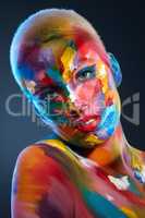 Not only is life not black and white, but its not solely in one color. Studio shot of a young woman posing with multi-coloured paint on her face.