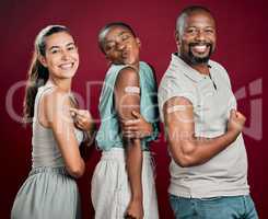Covid vaccinated diverse group of people showing plaster on arm. African american man and woman with mixed race woman isolated on red studio background with copyspace. Promote health in corona vaccine