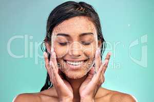 Focus on good skin care. a young woman washing her face with a product against a blue background.