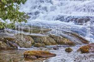 Mountain stream and waterfall rushing down over rocks and boulders. Beautiful nature landscape natural, fresh river flows between trees in an eco environment in Norway. Scenery on adventure walks