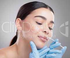 Nothing wron with enhancing your natural beauty. Studio shot of an attractive young woman having some plastic surgery done against a grey background.